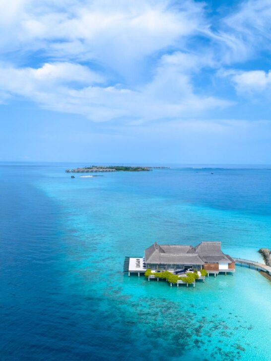 Luxury overwater villa surrounded by crystal-clear turquoise waters in the Maldives.