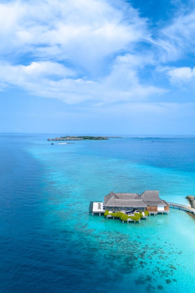 Luxury overwater villa surrounded by crystal-clear turquoise waters in the Maldives.
