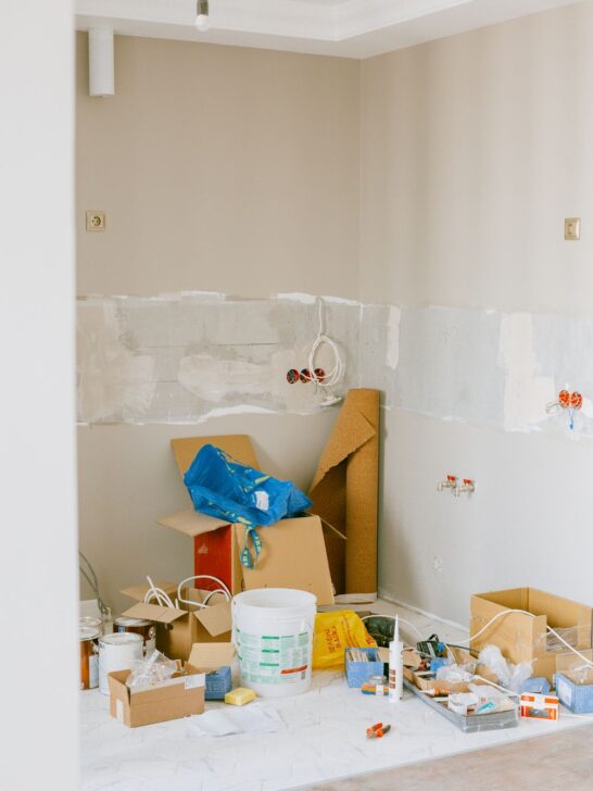 Room under renovation with tile installation, a step ladder, and worktable during a home remodeling project.