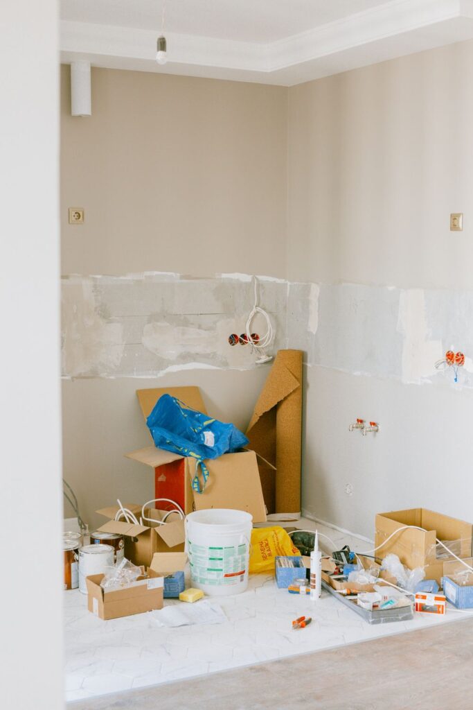 A room under renovation with tile installation, a step ladder, and worktable during a home remodeling project.