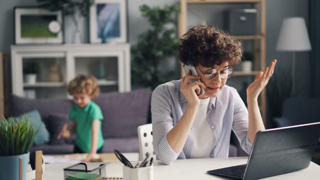 Small business owner using small business software to manage customer calls and daily operations from a home office.