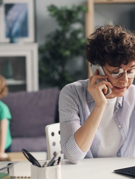 Small business owner using small business software to manage customer calls and daily operations from a home office.