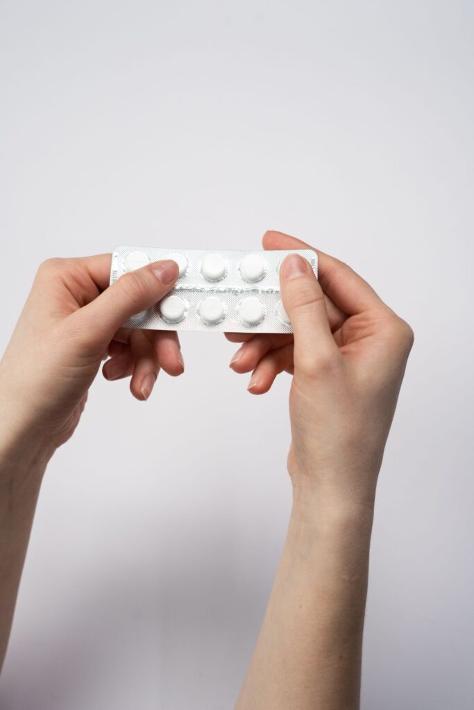 Birth control pill packs with a red rose on a pink background.
