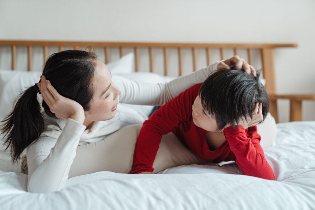 Mother talking with her young child while relaxing together on a bed