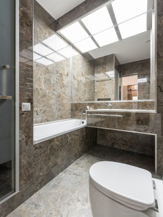 Natural stone interiors featuring marble walls, flooring, and a modern bathroom with a soaking tub and floating vanity