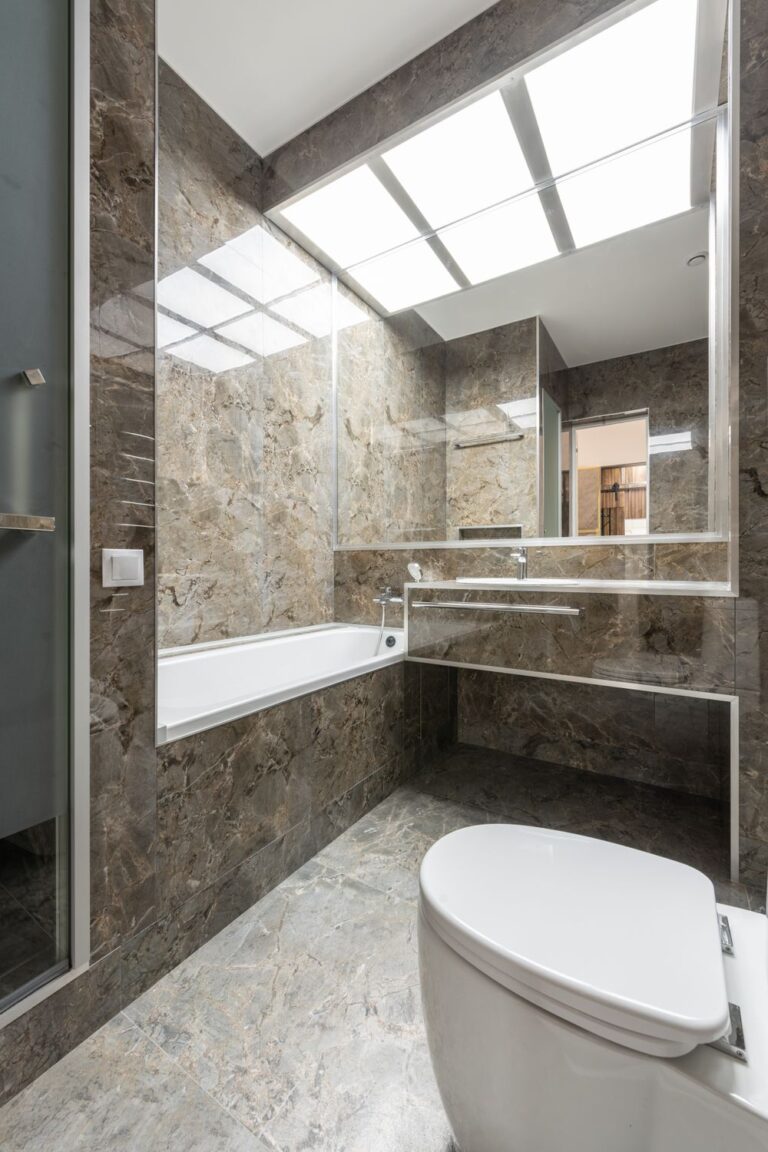 Natural stone interiors featuring marble walls, flooring, and a modern bathroom with a soaking tub and floating vanity
