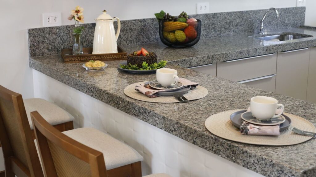 Spacious kitchen with granite countertops, bar seating, and elegant natural stone surfaces