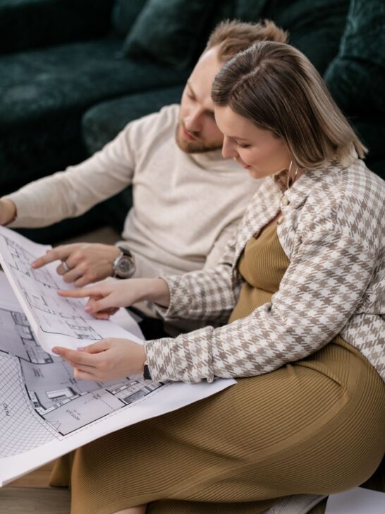 Couple reviewing floor plans while planning their new construction home