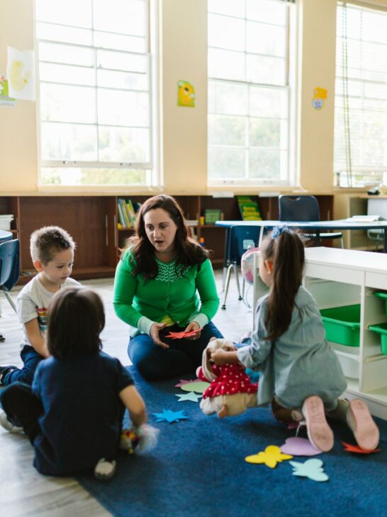 Teacher leading a small group activity to encourage social skills and emotional development in young children.