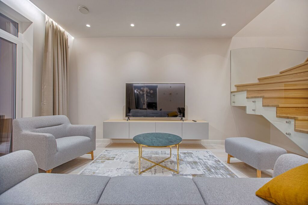 Modern living room with light-colored seating, a round coffee table, and small living room furniture arranged to create a more open feel.