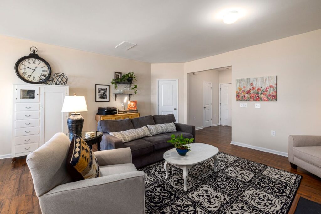 Bright living room with a sofa, accent chairs, and a round coffee table arranged to maximize space and improve traffic flow.