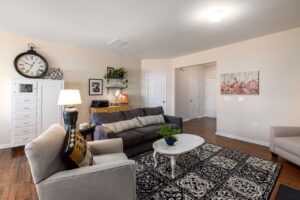 Bright living room with a sofa, accent chairs, and a round coffee table arranged to maximize space and improve traffic flow.