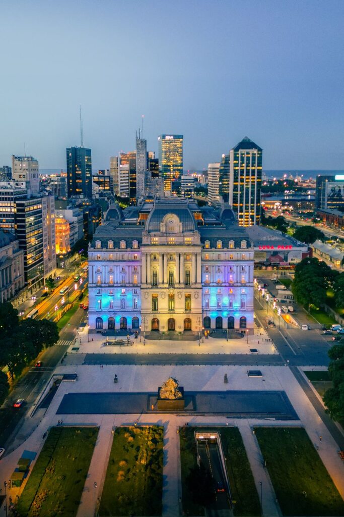 Aerial view of illuminated historic architecture and surrounding buildings in Buenos Aires.