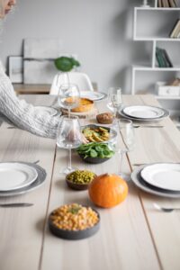 Fall dinner table set with a pumpkin and seasonal side dishes
