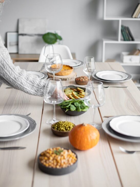 Fall dinner table set with a pumpkin and seasonal side dishes