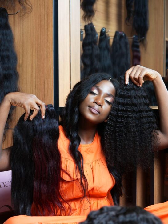 Woman comparing long straight and curly hair options for a drawstring wig vs human hair weave.