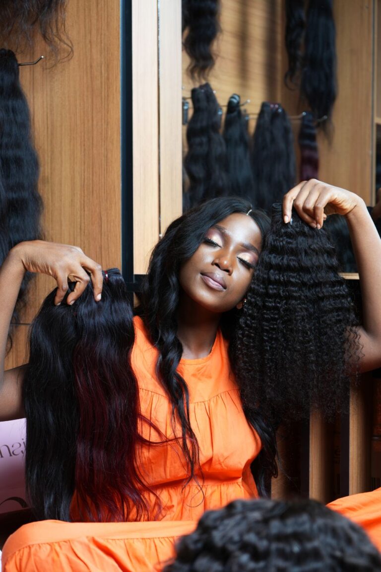 Woman comparing long straight and curly hair options for a drawstring wig vs human hair weave.
