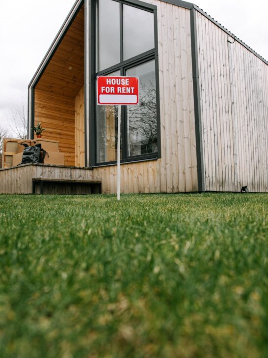 Rental house with a for-rent sign representing an emergency maintenance budget for rental property expenses