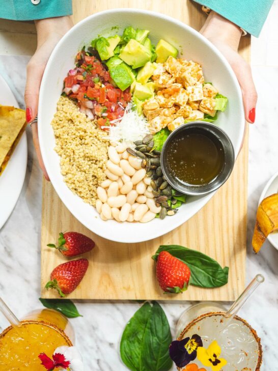 Healthy lunch ideas with quinoa, chicken, white beans, avocado, vegetables, and seeds in a bowl