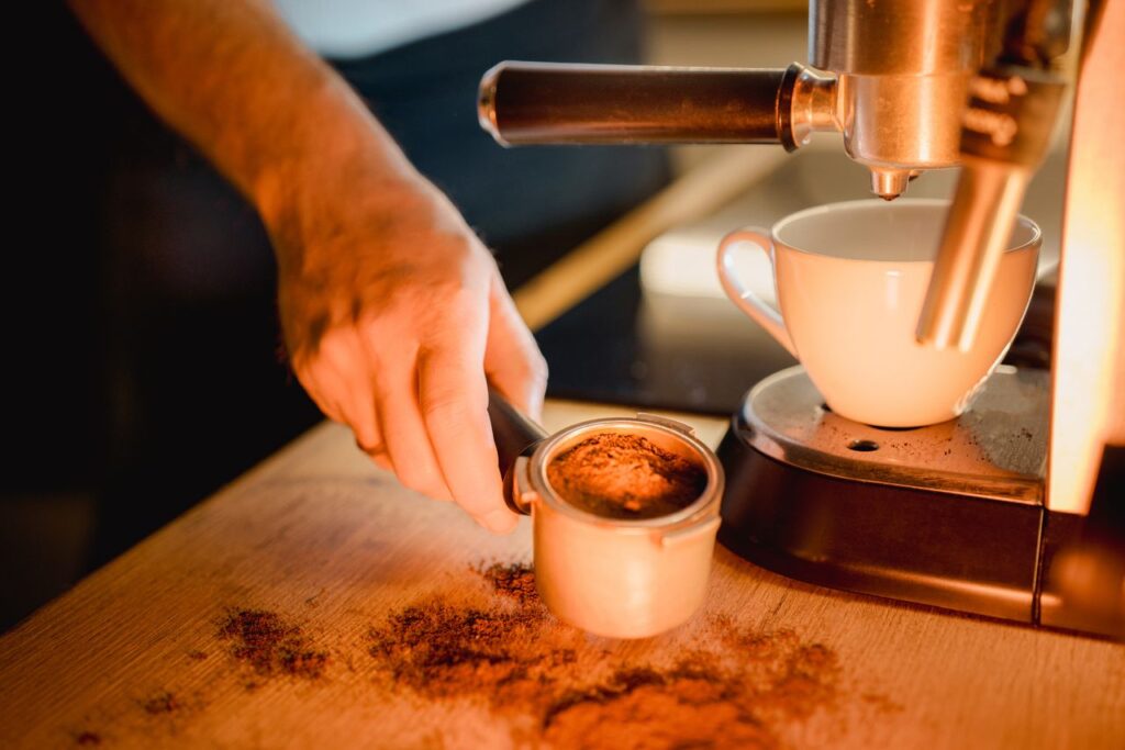Home coffee experience with a person preparing espresso using an at-home espresso machine.