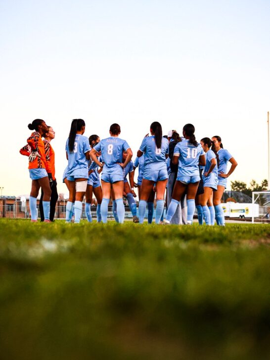 soccer players gathered for a team meeting on the field