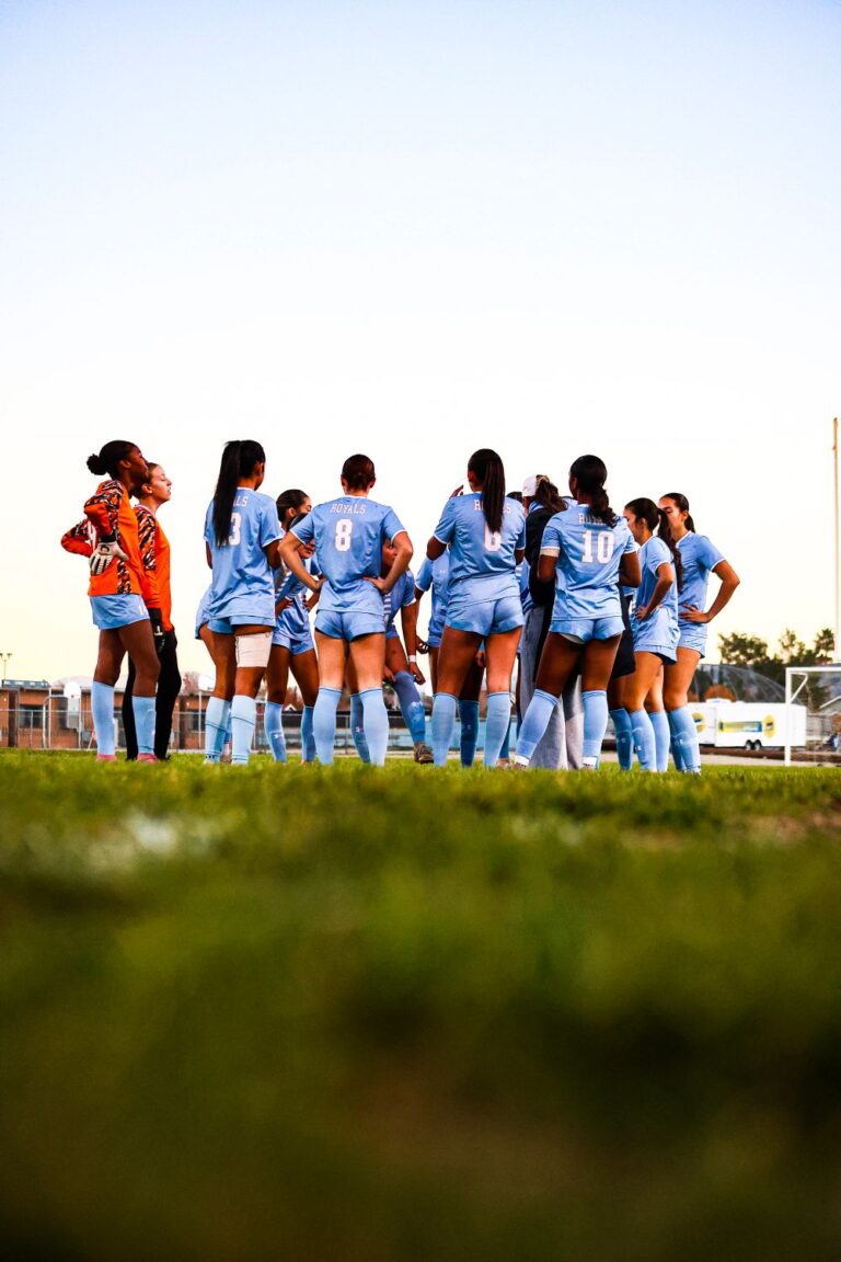 soccer players gathered for a team meeting on the field