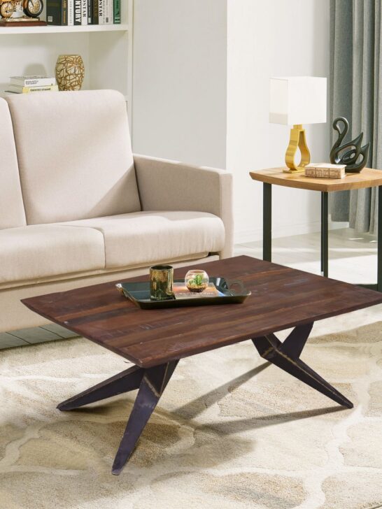 Stylish wooden coffee table with metal legs positioned in front of a neutral sofa in a modern living room.
