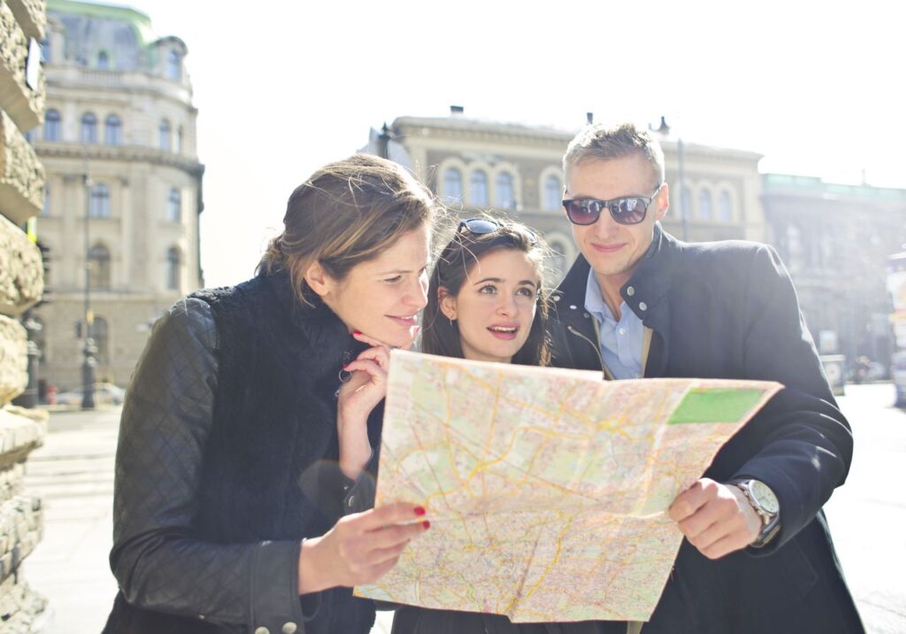 Three travelers looking at a city map while sightseeing