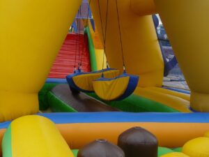 Colorful course with hanging obstacles and a climbing ramp, an example for parents buying an inflatable obstacle course.