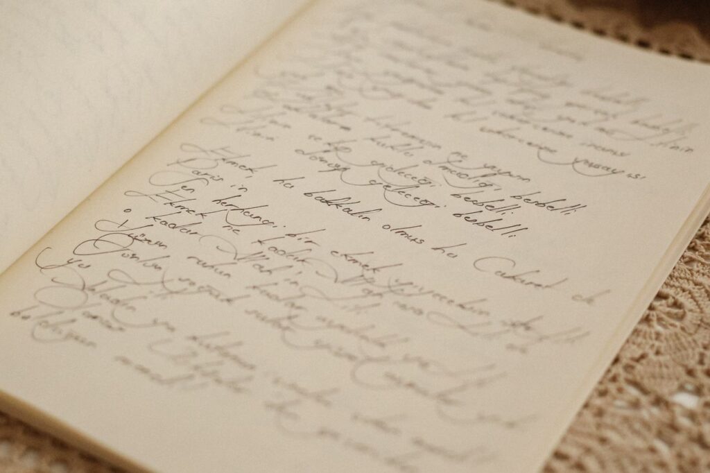 Close-up of cursive handwriting in an open journal resting on a lace tablecloth.