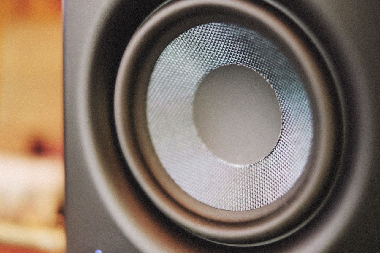 Close-up of a speaker’s silver woven cone and black surround.