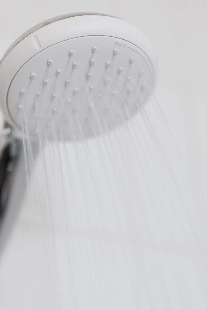 Close-up of a white showerhead spraying water, highlighting water flow and showerhead performance.